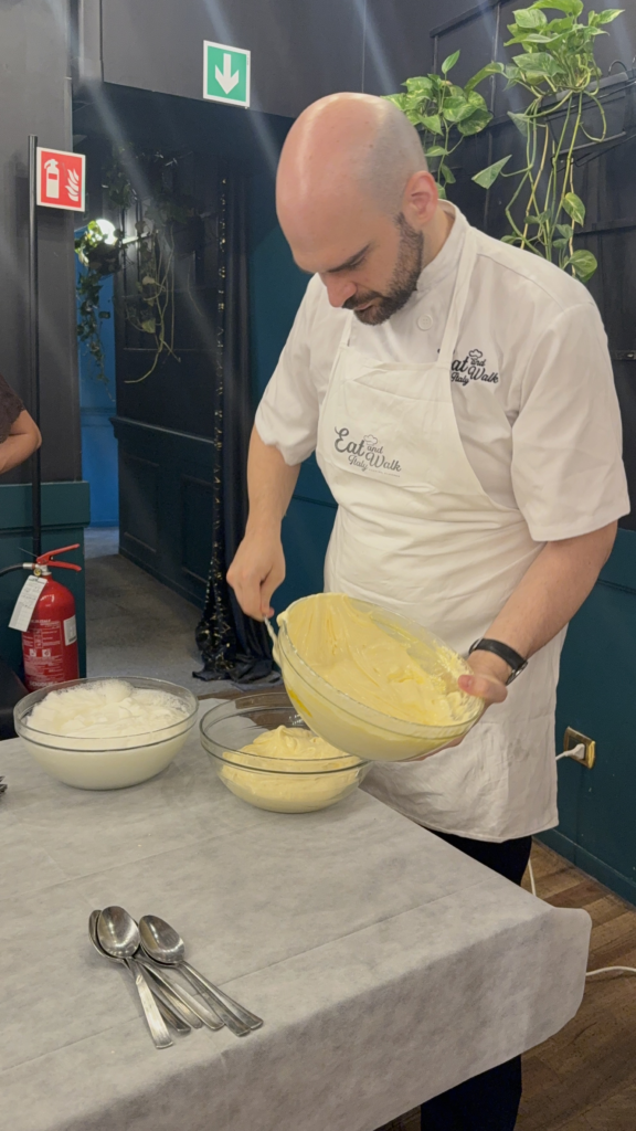 A chef preparing tiramisu at a cooking class.